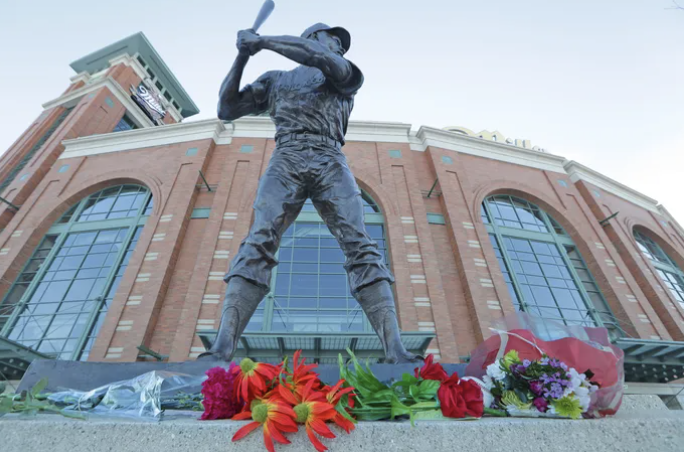 Baseball player statue outside American Family Field with flowers at its base